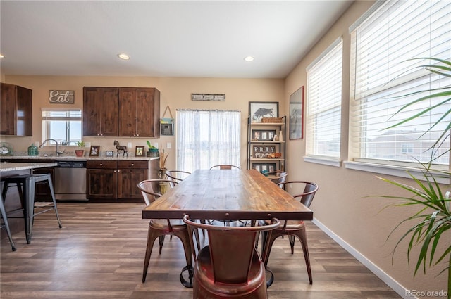 dining area with baseboards, wood finished floors, and recessed lighting