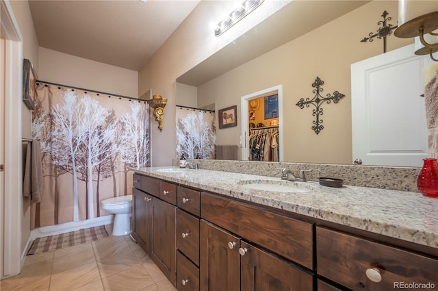 bathroom with toilet, a sink, and double vanity