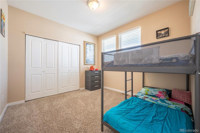 carpeted bedroom with baseboards and a closet