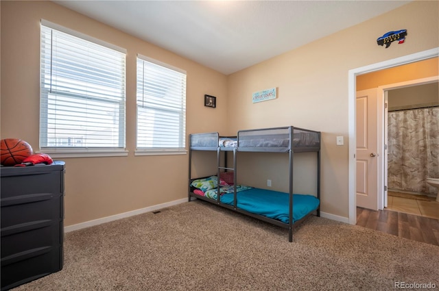 bedroom with baseboards and carpet