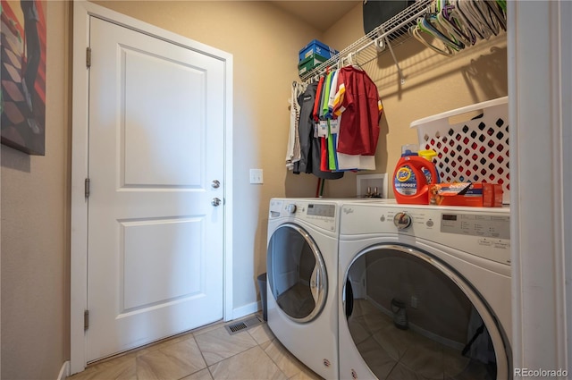 laundry area featuring washer and dryer, baseboards, laundry area, and light tile patterned floors