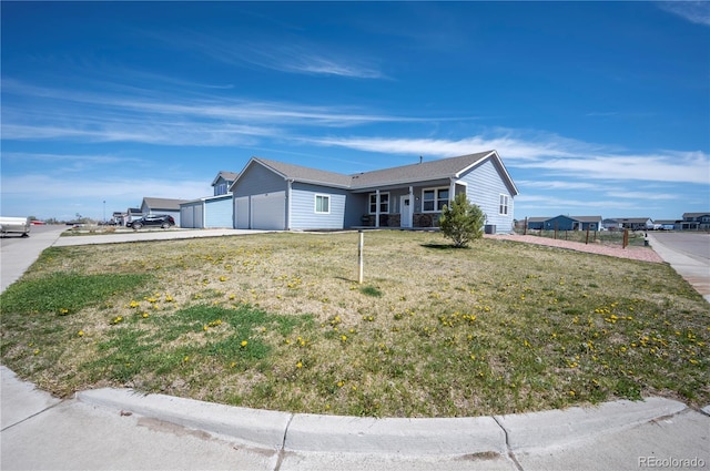 view of front of house featuring fence, concrete driveway, a front yard, and a garage