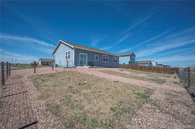 rear view of property featuring a fenced backyard
