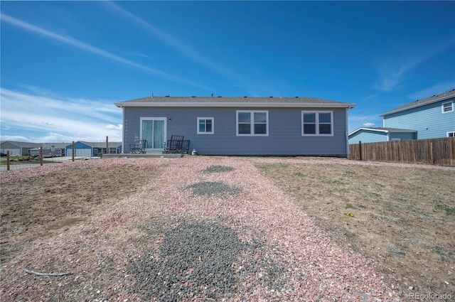 rear view of property featuring fence