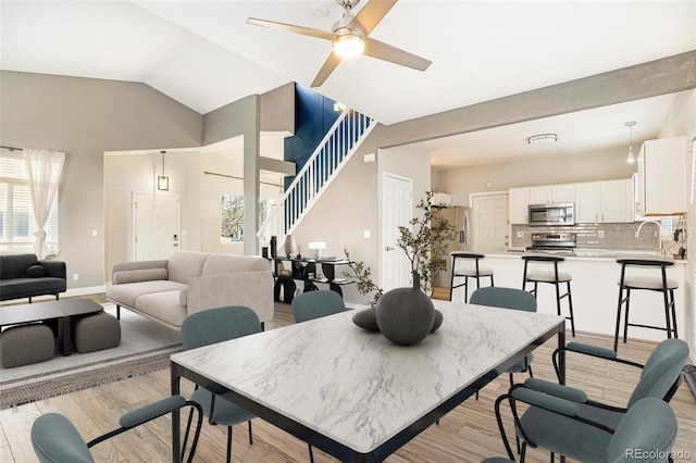 dining room with lofted ceiling, sink, light hardwood / wood-style flooring, and ceiling fan