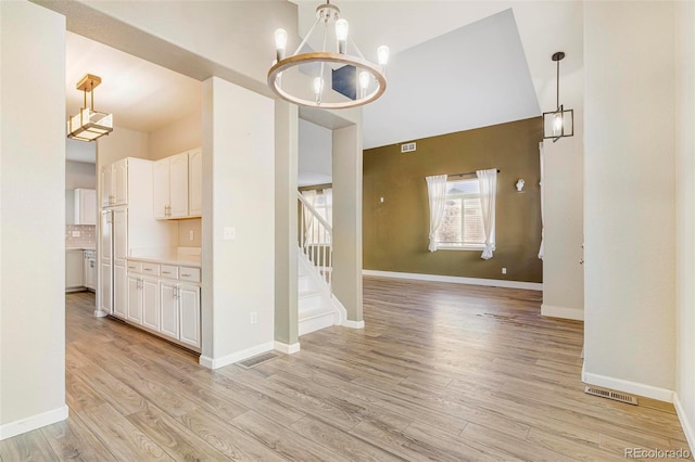 interior space with an inviting chandelier and light hardwood / wood-style floors