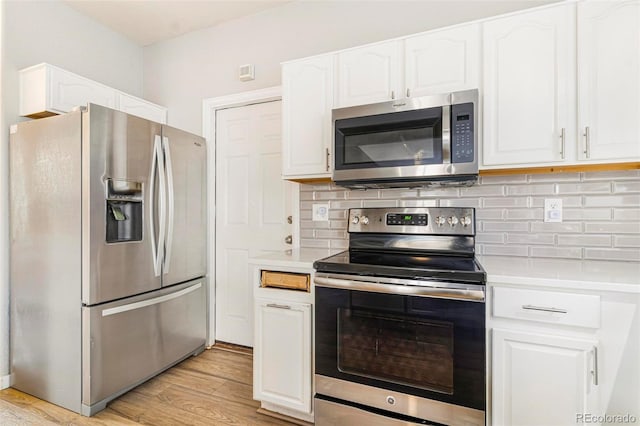 kitchen with decorative backsplash, light hardwood / wood-style flooring, stainless steel appliances, and white cabinets