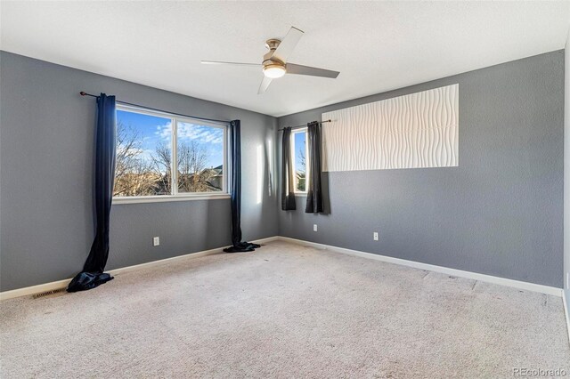 carpeted spare room featuring ceiling fan