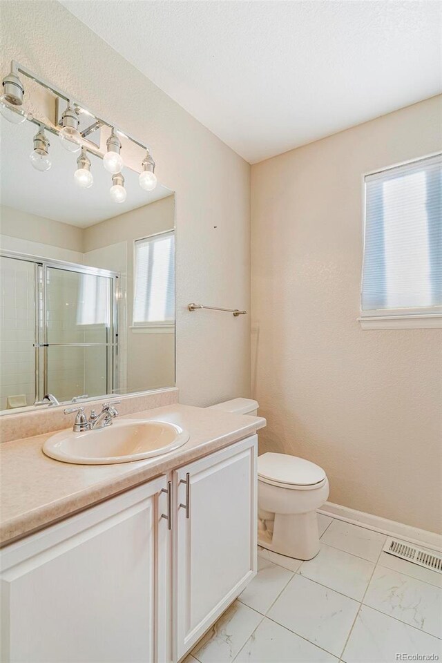 bathroom featuring vanity, toilet, and walk in shower