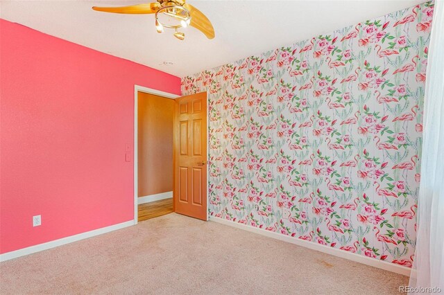 empty room featuring carpet floors and ceiling fan