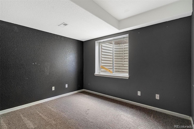 spare room featuring a textured ceiling and carpet