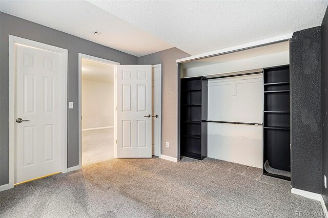 unfurnished bedroom with carpet floors, a closet, and a textured ceiling