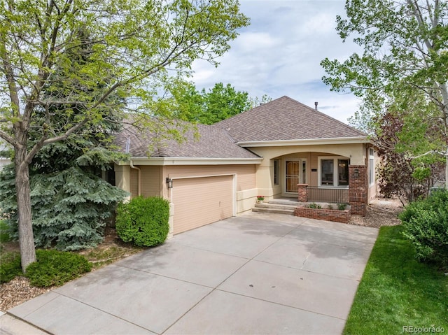15851 Deer Ridge Dr, Morrison, CO 80465 - view of front of home with roof with shingles, a porch, concrete driveway, and an attached garage