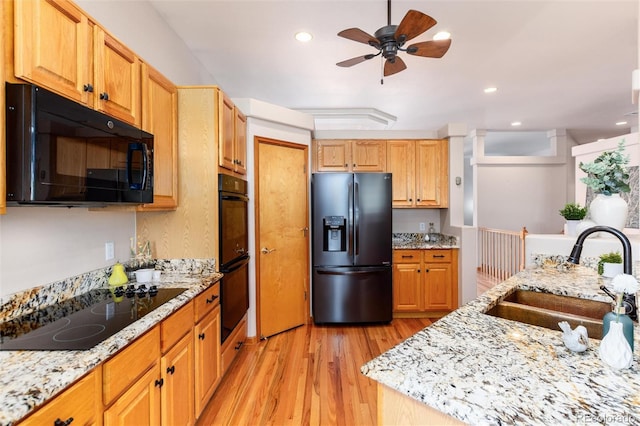 15851 Deer Ridge Dr, Morrison, CO 80465 - kitchen featuring black appliances, a sink, light wood finished floors, a ceiling fan, and light stone counters