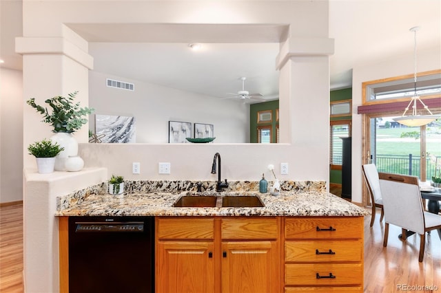 15851 Deer Ridge Dr, Morrison, CO 80465 - kitchen featuring black dishwasher, a sink, light wood-style flooring, and light stone counters