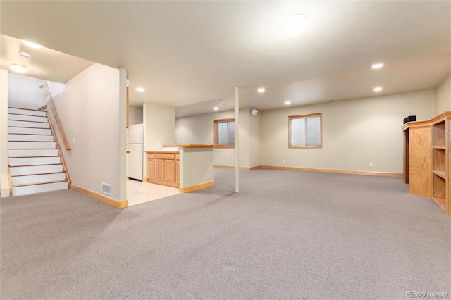 15851 Deer Ridge Dr, Morrison, CO 80465 - basement with freestanding refrigerator, light colored carpet, recessed lighting, baseboards, and stairs