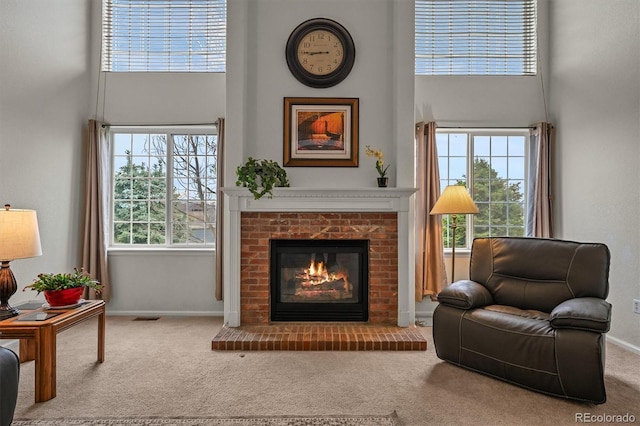 1120 N Calhan Ave, Castle Rock, CO 80104 - living room featuring carpet floors, a high ceiling, a brick fireplace, and healthy amount of natural light