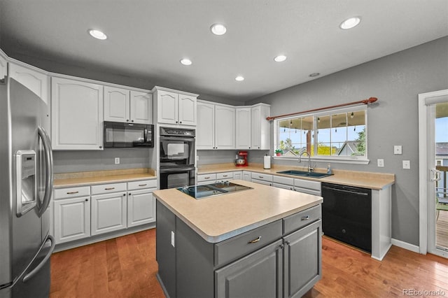 1120 N Calhan Ave, Castle Rock, CO 80104 - kitchen with black appliances, a sink, gray cabinets, white cabinets, and light wood finished floors