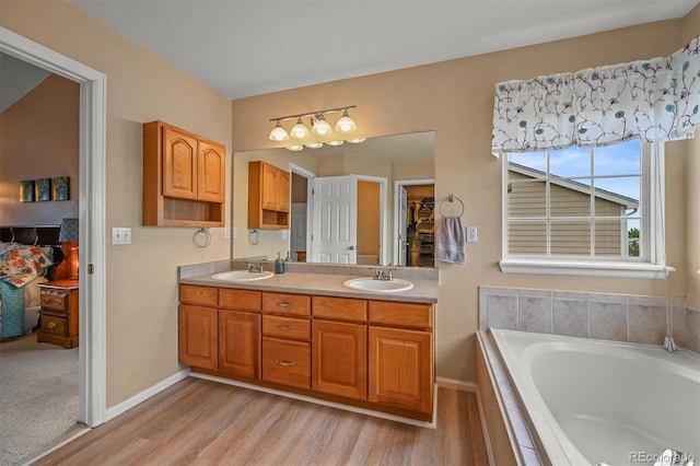 1120 N Calhan Ave, Castle Rock, CO 80104 - full bathroom with double vanity, a bath, wood finished floors, and baseboards