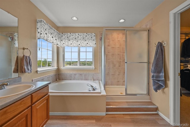 1120 N Calhan Ave, Castle Rock, CO 80104 - full bath featuring a stall shower, vanity, a spacious closet, a garden tub, and wood finished floors
