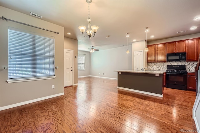 8883 White Prairie Vw, Colorado Springs, CO 80924 - kitchen with black appliances, a chandelier, decorative backsplash, wood finished floors, and recessed lighting
