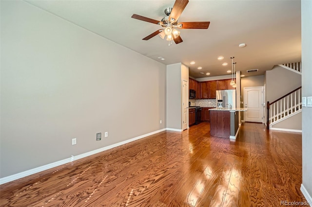 8883 White Prairie Vw, Colorado Springs, CO 80924 - unfurnished living room featuring dark wood finished floors, ceiling fan, stairway, and recessed lighting