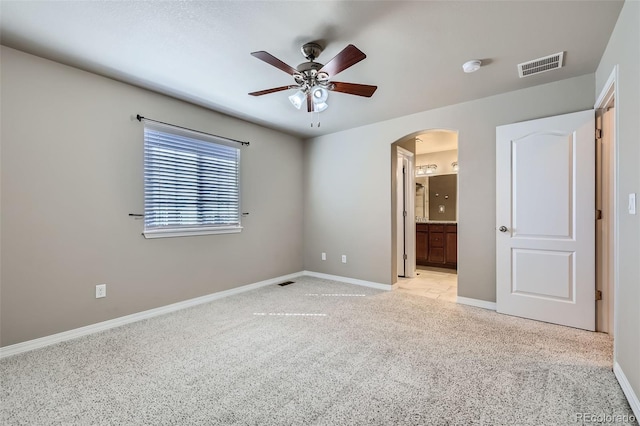8883 White Prairie Vw, Colorado Springs, CO 80924 - unfurnished bedroom with arched walkways, light carpet, connected bathroom, and a ceiling fan