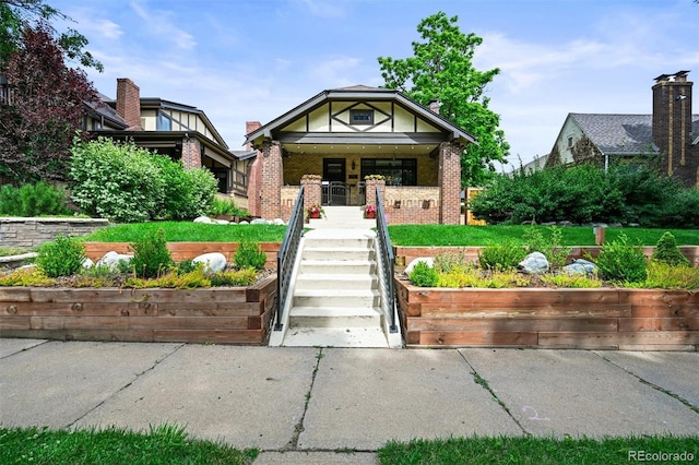 1414 S Vine St, Denver, CO 80210 - tudor house featuring brick siding, stairs, and a porch