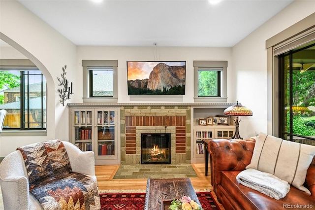 1414 S Vine St, Denver, CO 80210 - living area featuring arched walkways, a brick fireplace, and wood finished floors