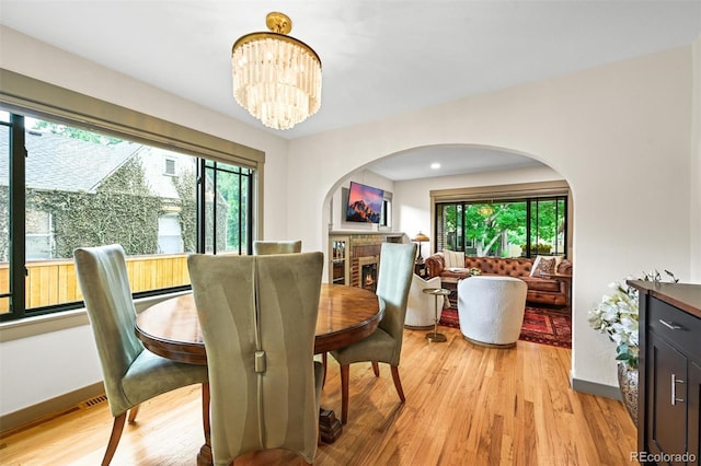 1414 S Vine St, Denver, CO 80210 - dining area featuring healthy amount of natural light, a chandelier, arched walkways, and light wood-type flooring