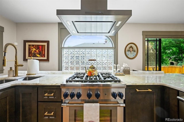 1414 S Vine St, Denver, CO 80210 - kitchen featuring extractor fan, high end stainless steel range oven, light stone counters, and dark brown cabinets