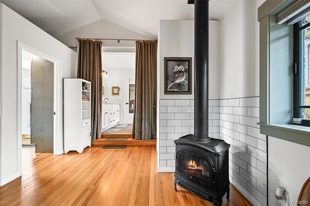 1414 S Vine St, Denver, CO 80210 - unfurnished living room with a wood stove, light wood-style floors, and vaulted ceiling