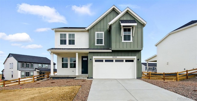 view of front of home with a garage, board and batten siding, driveway, and fence