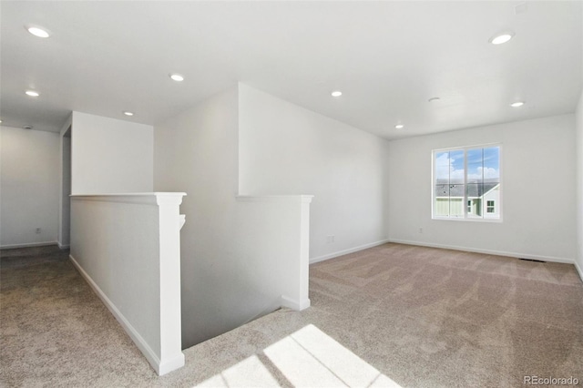 empty room featuring recessed lighting, baseboards, and carpet flooring