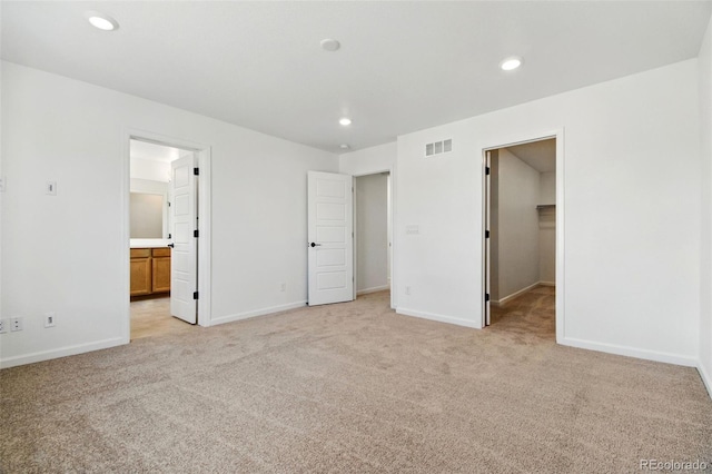 unfurnished bedroom with light carpet, visible vents, and recessed lighting