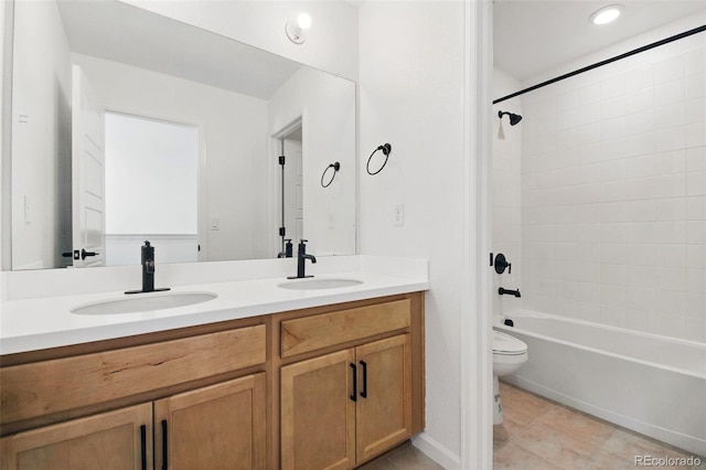 bathroom featuring tile patterned flooring, double vanity, toilet, and a sink