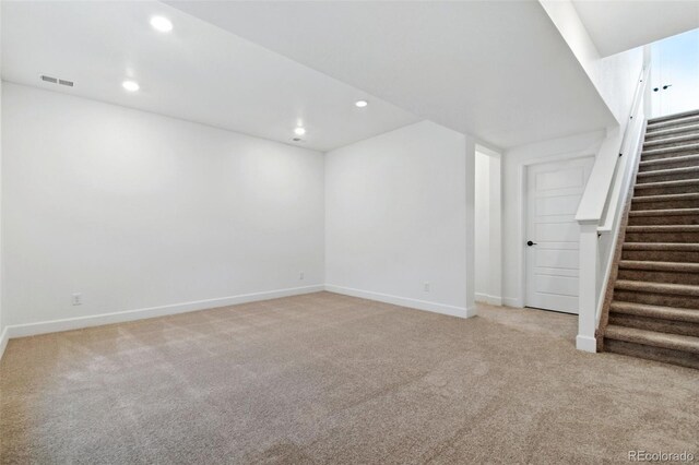 basement featuring light carpet, visible vents, recessed lighting, and stairway