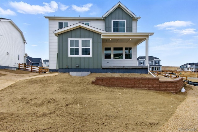 rear view of house featuring fence and board and batten siding