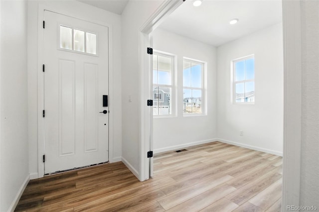 foyer entrance with light wood finished floors, visible vents, recessed lighting, and baseboards