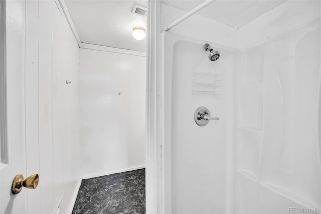 bathroom with a shower and wood walls