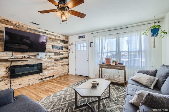 1822 N Circle Dr, Colorado Springs, CO 80909 - living room featuring wooden walls, a ceiling fan, and wood finished floors