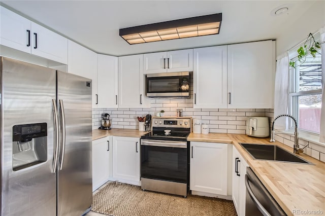 1822 N Circle Dr, Colorado Springs, CO 80909 - kitchen with wooden counters, appliances with stainless steel finishes, a sink, and tasteful backsplash