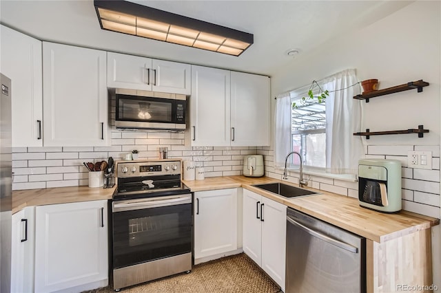 1822 N Circle Dr, Colorado Springs, CO 80909 - kitchen with wooden counters, appliances with stainless steel finishes, a sink, backsplash, and white cabinetry