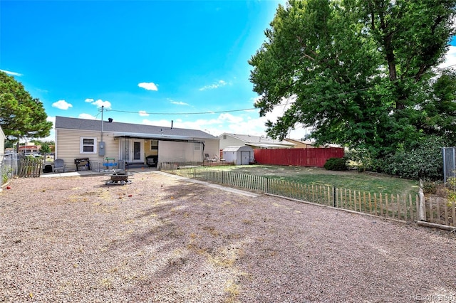 1822 N Circle Dr, Colorado Springs, CO 80909 - rear view of property featuring a fire pit, a storage shed, a fenced backyard, and an outdoor structure