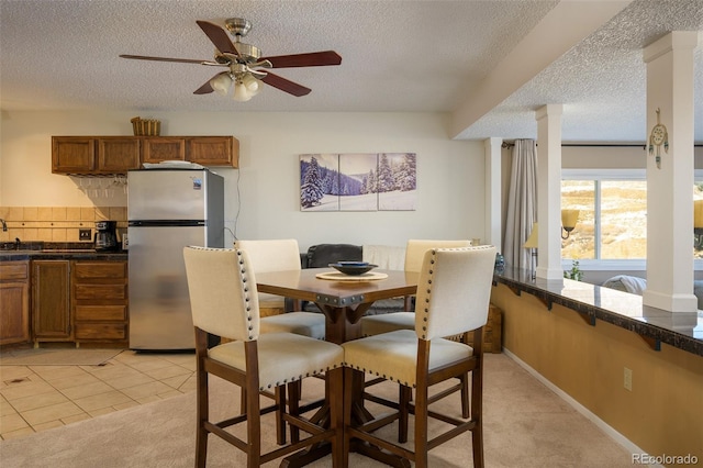 tiled dining room featuring ceiling fan and a textured ceiling