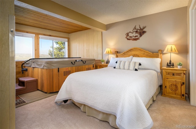 carpeted bedroom with beamed ceiling and a textured ceiling