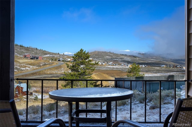 snow covered back of property with a mountain view