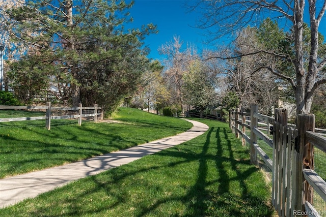 view of property's community featuring a yard and fence