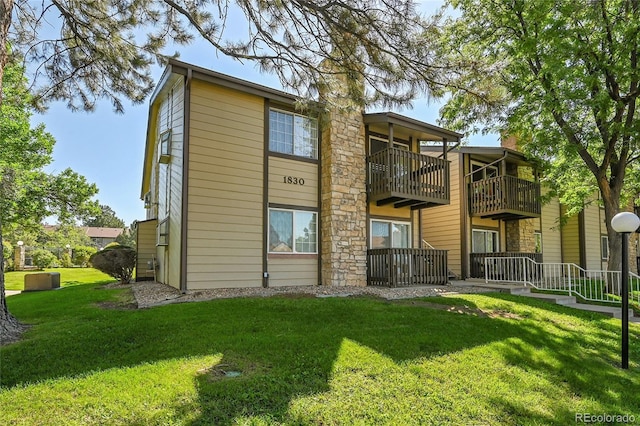 1830 S Pitkin Cir Unit B, Aurora, CO 80017 - rear view of house with a lawn and a balcony