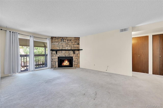 1830 S Pitkin Cir Unit B, Aurora, CO 80017 - unfurnished living room with a textured ceiling, a stone fireplace, and carpet flooring